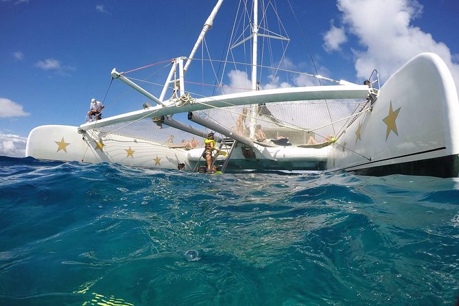 Catamaran Day Trip, Snorkeling & Sailing Excursion - Boarding a catamaran from the beach