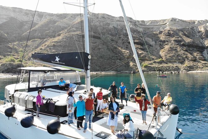 Half-Day Exclusive Catamaran Cruise in Santorini with Meal and Open Bar - What the Catamaran Atmosphere Is Like