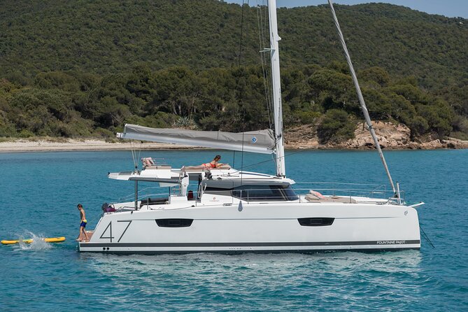Mykonos: Brand-New Catamaran Cruise with Meal, Drinks & Transport - Sailing away from Mykonos at Agia Anna