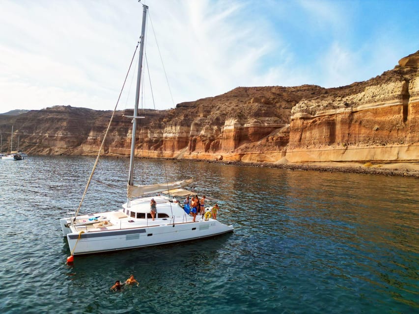 Santorini: Catamaran Cruise with Greek BBQ and Drinks - White Beach and the Sea Caves