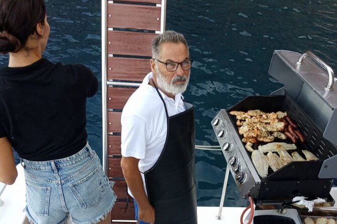 Santorini Catamaran Cruise with Meal and Drinks - Swimming and snorkeling in clear coastal water