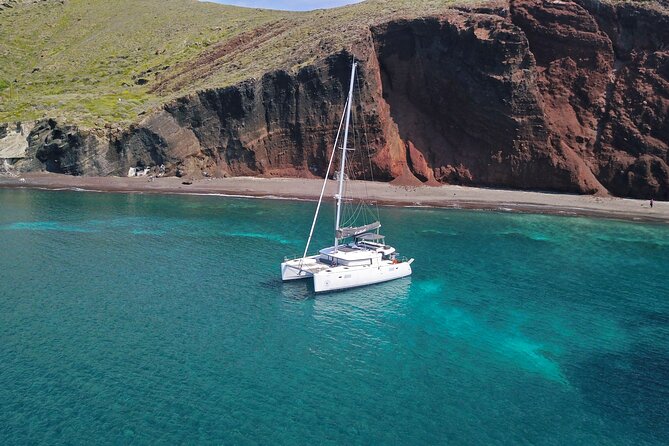 Santorini: Luxury Catamaran Cruise with Fresh Fish BBQ & Drinks - White Beach and the changing volcanic colors