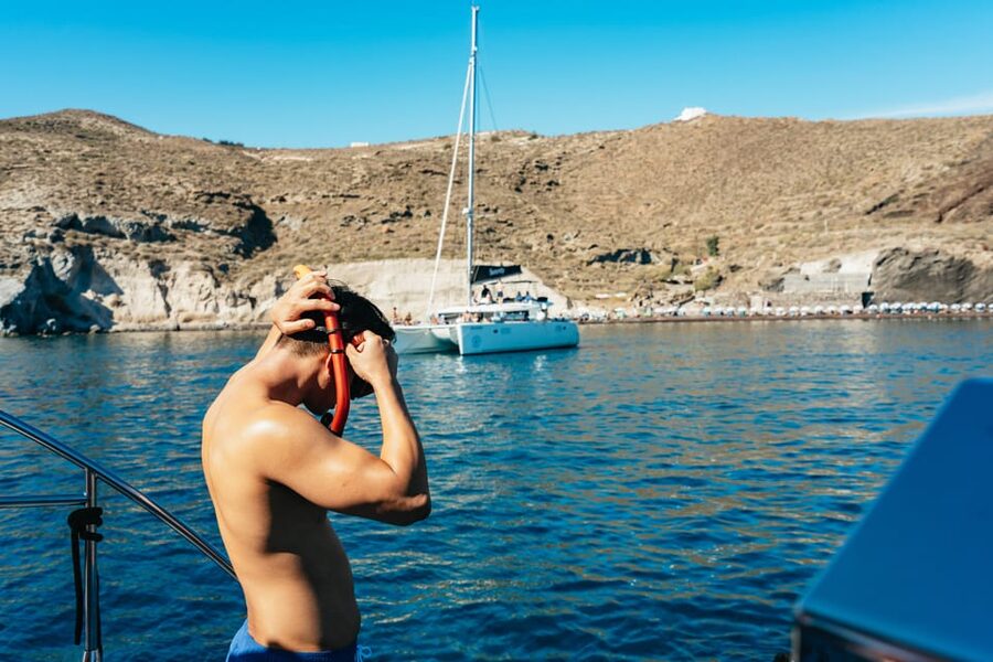 Santorini: Sailing Catamaran Cruise with BBQ and Drinks - Lighthouse views and the volcanic coast